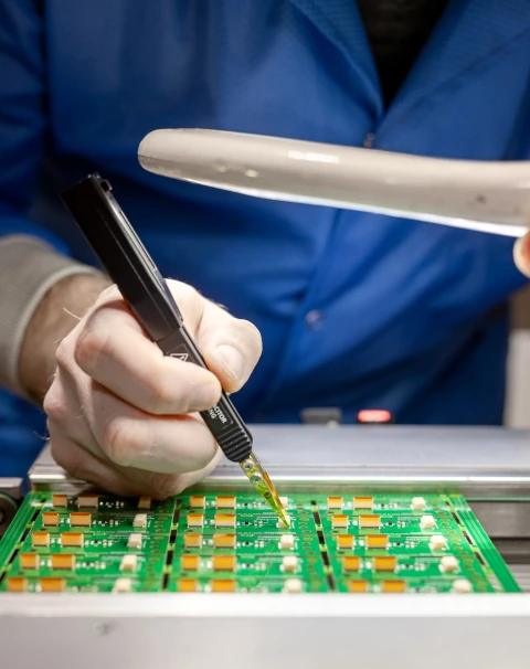 SMT technician inspecting a PCB